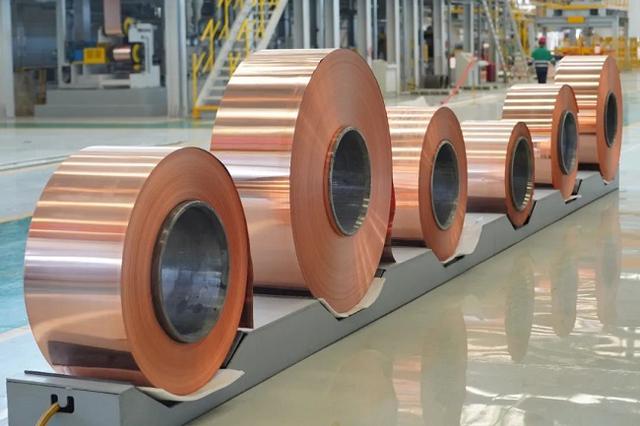 Person standing in a factory with machinery in the background