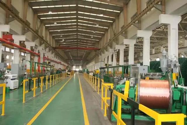 Person standing in a factory with machinery in the background