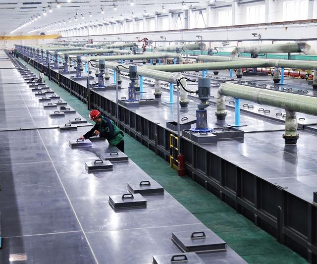 Person standing in a factory with machinery in the background