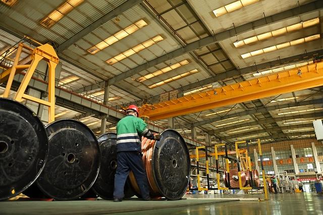 Person standing in a factory with machinery in the background
