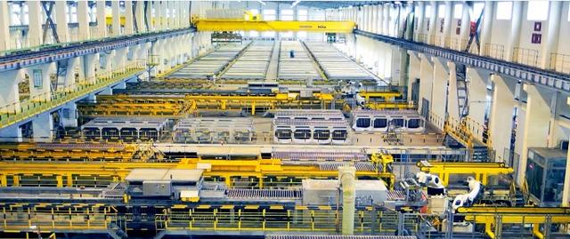 Person standing in a factory with machinery in the background