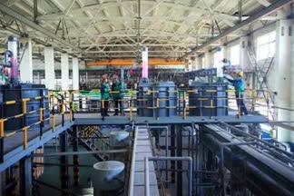 Person standing in a factory with machinery in the background