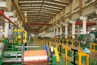Person standing in a factory with machinery in the background